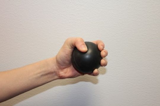 Henkilö puristelee pehmeää palloa.